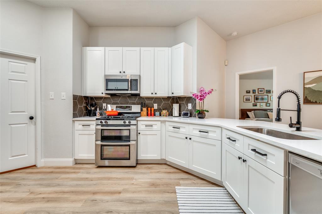 7306 Vista Ridge Lane Sachse, TX 75048 - Photo 4 of 23 a kitchen with cabinets stainless steel appliances and a sink