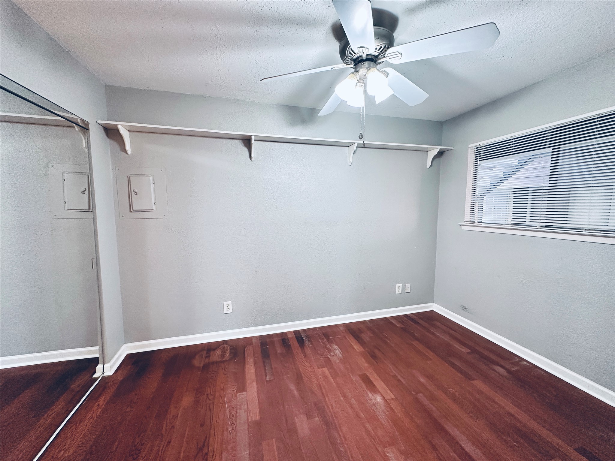 2500 Burleson Road, Unit 209 Austin, TX 78741 - Photo 14 of 24 Rich hardwood flooring complements this bedroom, featuring a convenient ceiling fan and ample natural light.