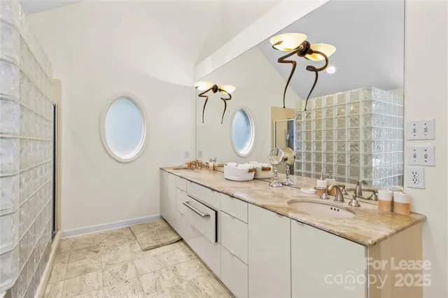 a bathroom with a granite countertop sink mirror and vanity