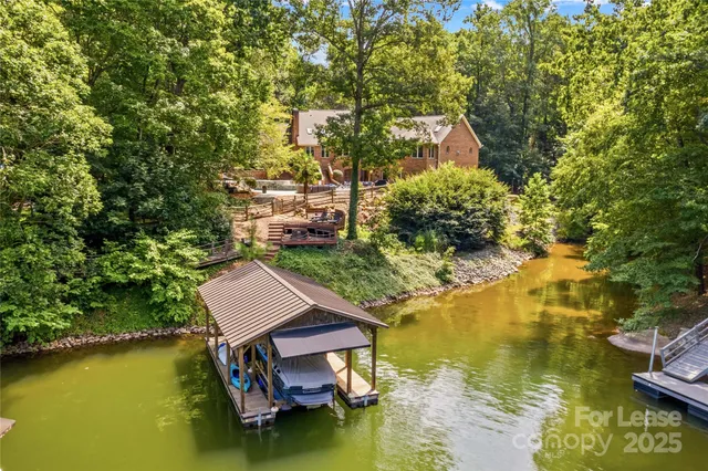 a small pool with lawn chairs and large trees