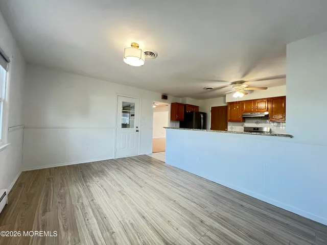 a view of empty room with wooden floor