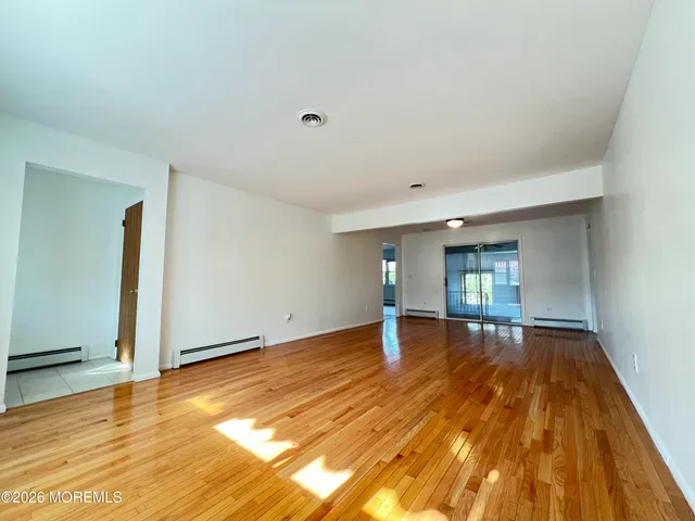 a view of empty room with wooden floor