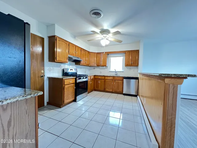 a kitchen with stainless steel appliances granite countertop a stove sink and cabinets