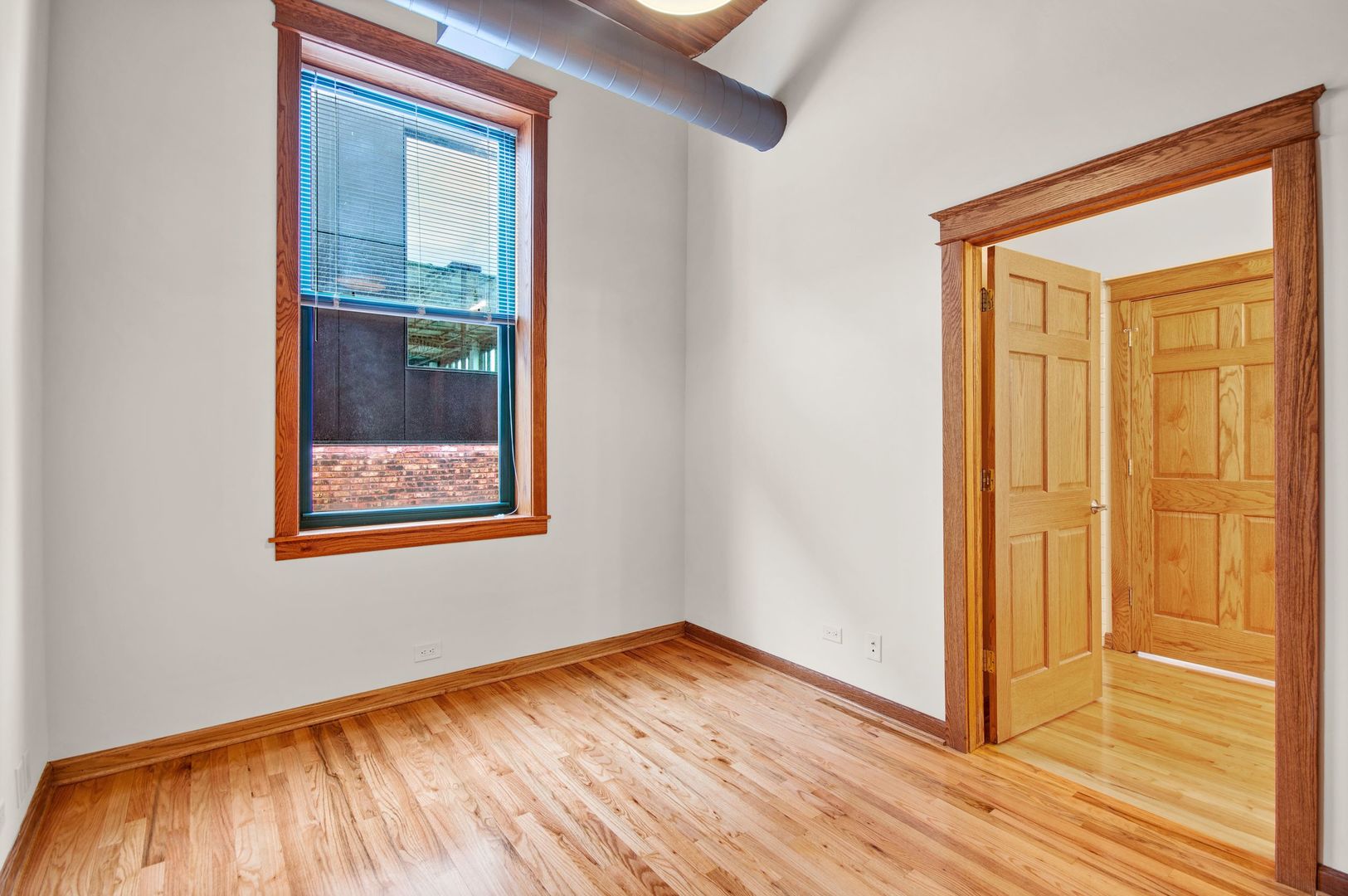216 North May Street, Unit 403 Chicago, IL 60607 - Photo 13 of 18 a view of an empty room with wooden floor and a window