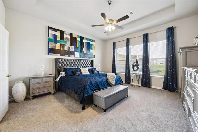 a spacious bedroom with a bed couch and a large window