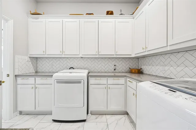 a kitchen with white cabinets and sink