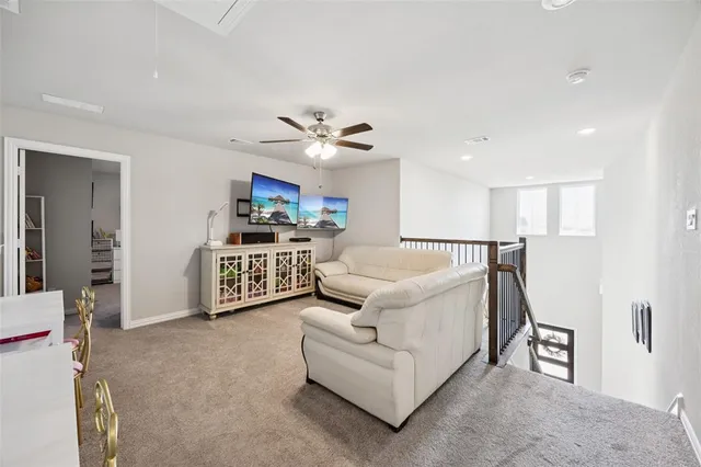 a living room with furniture and a ceiling fan