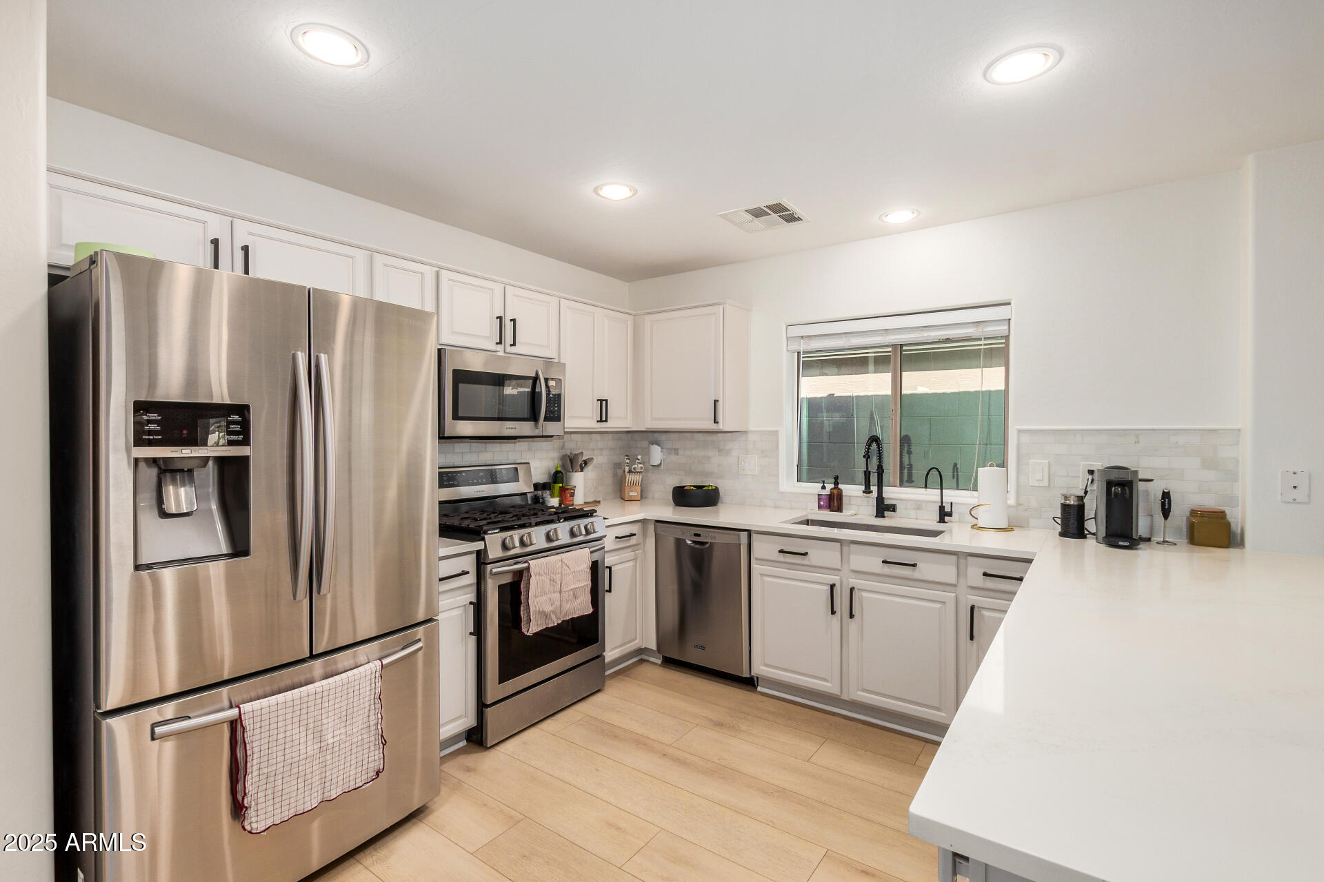 3433 East Hopkins Road Gilbert, AZ 85295 - Photo 18 of 38 a kitchen with stainless steel appliances granite countertop a refrigerator stove microwave and sink
