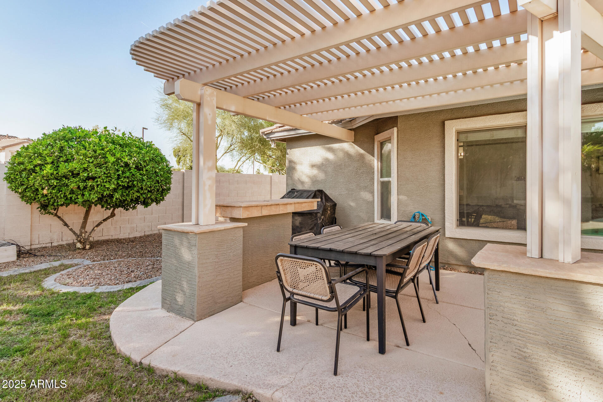 3433 East Hopkins Road Gilbert, AZ 85295 - Photo 34 of 38 a patio with a table and chairs and potted plants