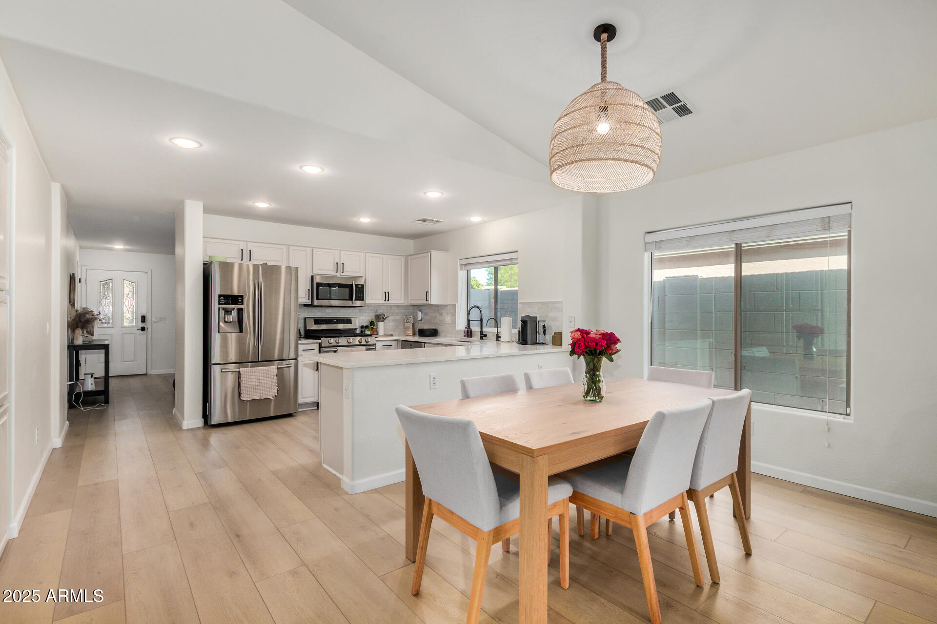 3433 East Hopkins Road Gilbert, AZ 85295 - Photo 4 of 38 a kitchen with stainless steel appliances kitchen island granite countertop a dining table chairs and white cabinets