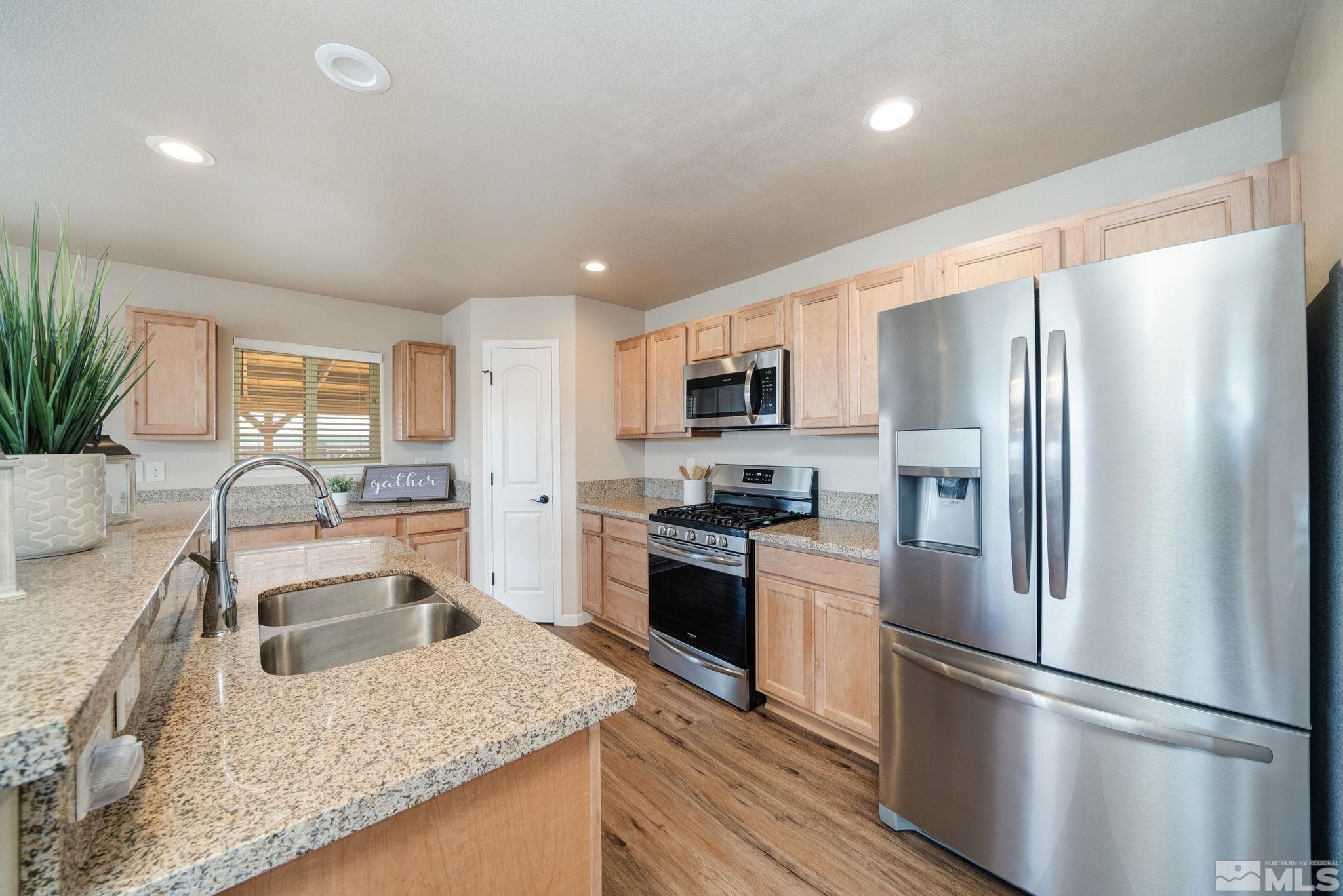 2513 Ladera Fallon, NV 89406 - Photo 12 of 30 a kitchen with stainless steel appliances granite countertop a refrigerator a stove a sink a oven with a dining table and chairs