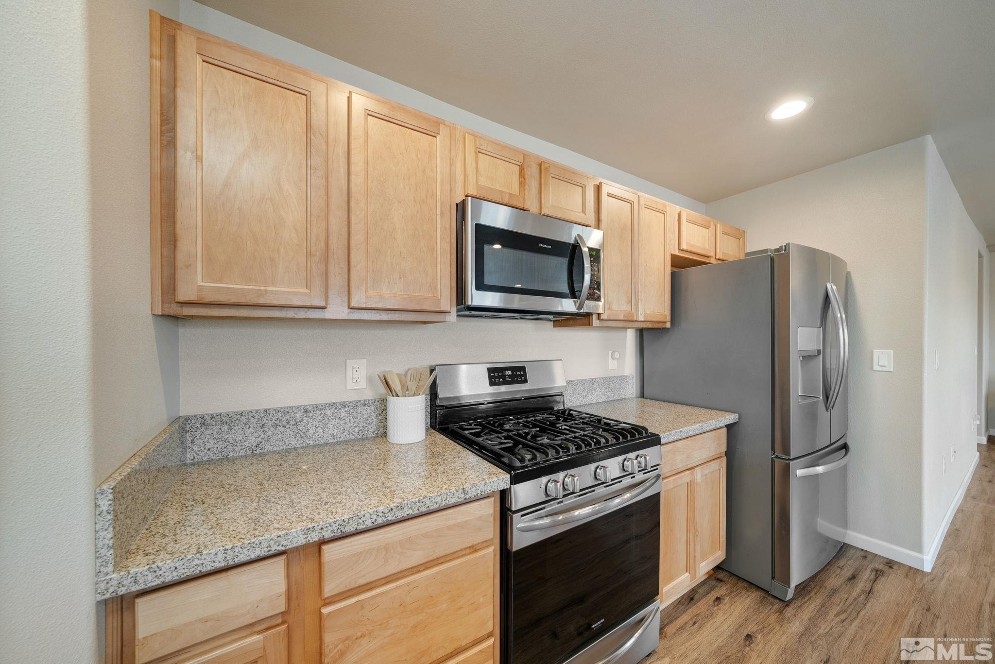 2513 Ladera Fallon, NV 89406 - Photo 13 of 30 a kitchen with granite countertop cabinets stainless steel appliances and wooden floor