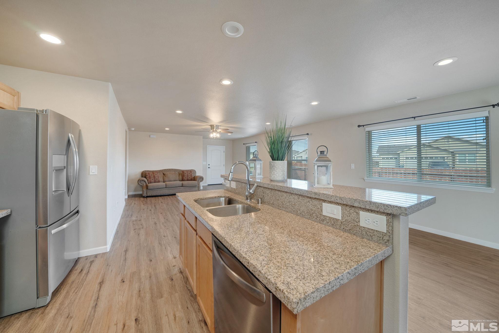 2513 Ladera Fallon, NV 89406 - Photo 14 of 30 a kitchen with granite countertop center island wooden floor and stainless steel appliances