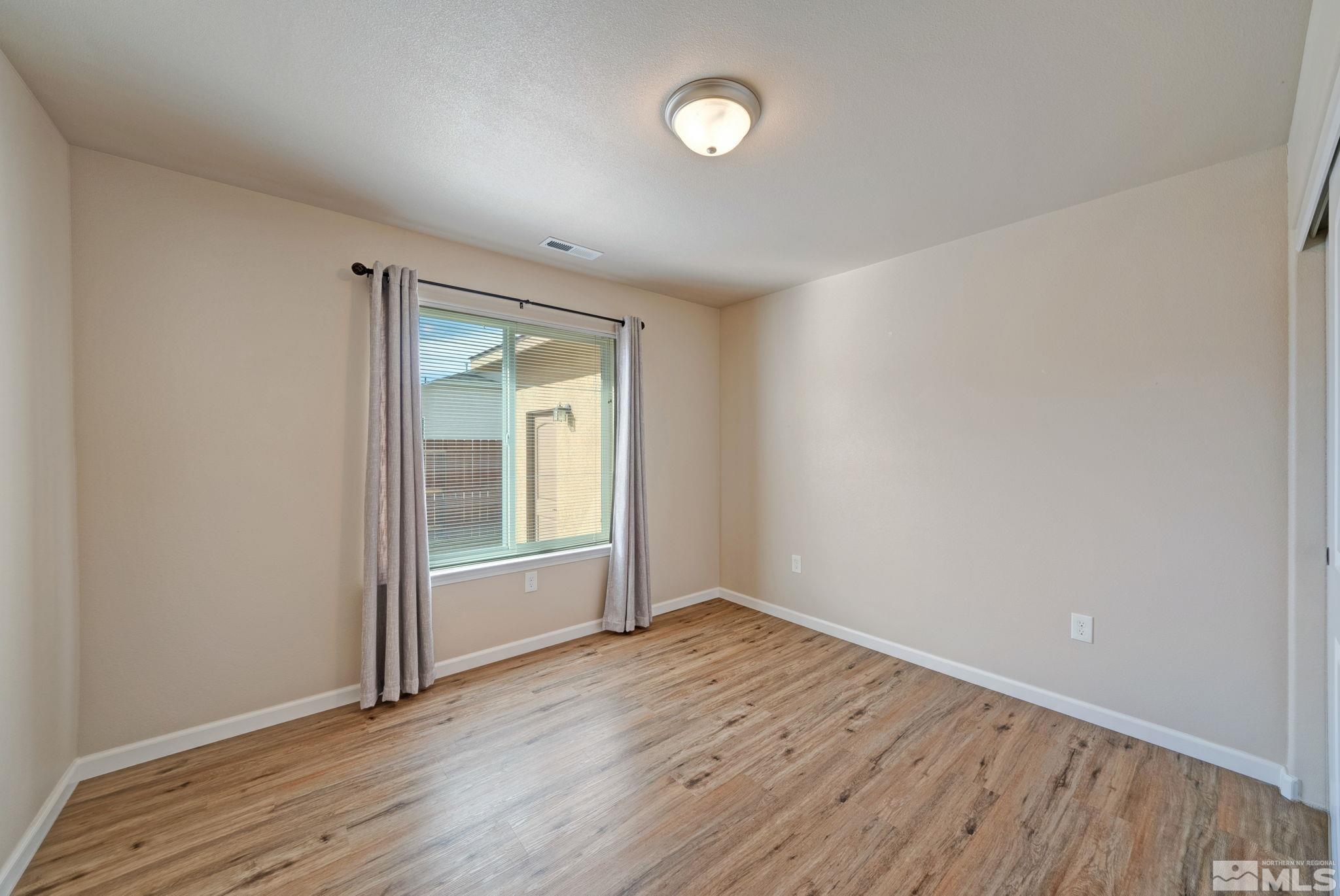 2513 Ladera Fallon, NV 89406 - Photo 19 of 30 a view of an empty room with wooden floor and a window