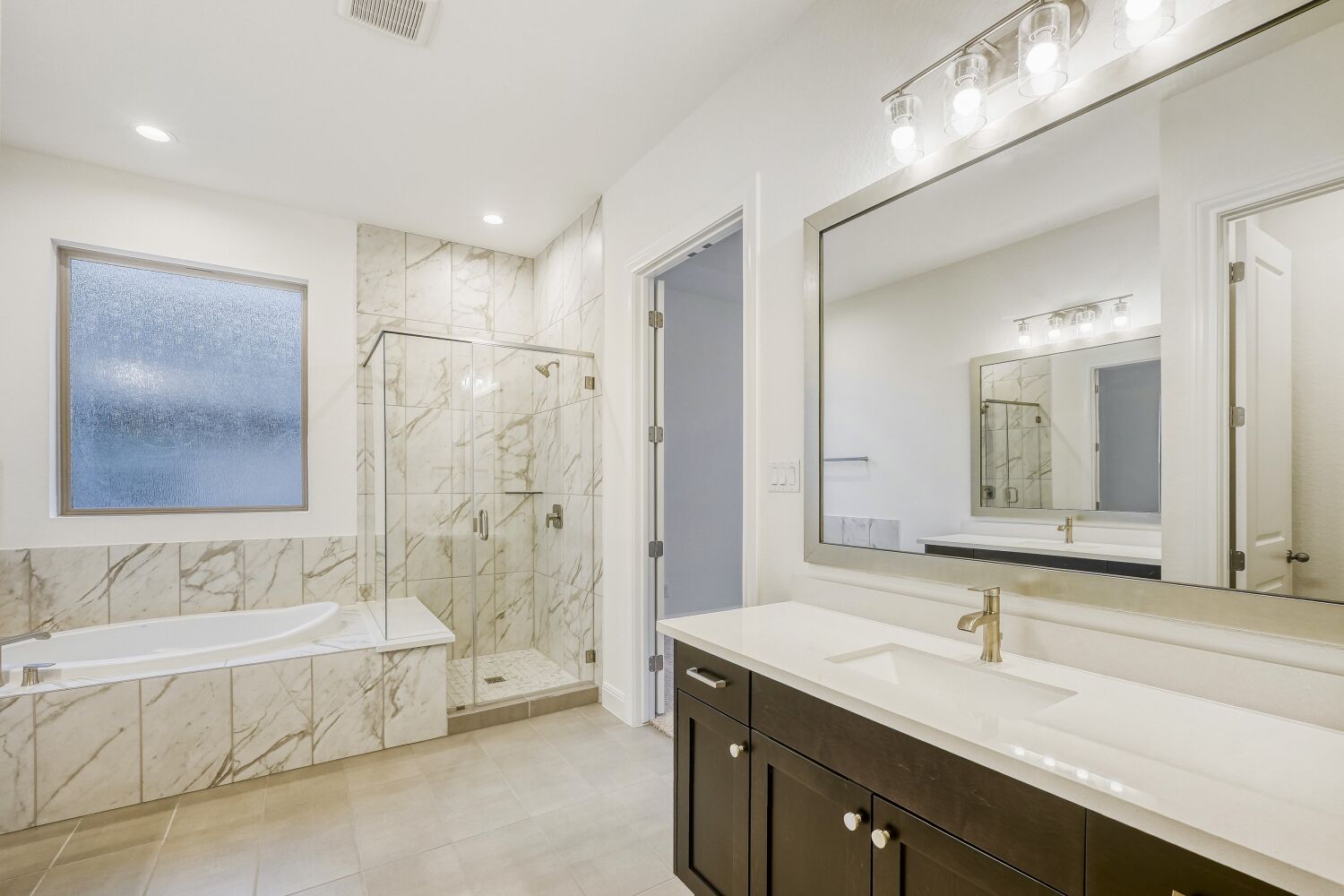 222 Prickly Poppy Loop Kyle, TX 78640 - Photo 7 of 11 a bathroom with a bathtub a double vanity sink and mirror
