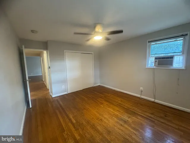 a view of empty room with wooden floor