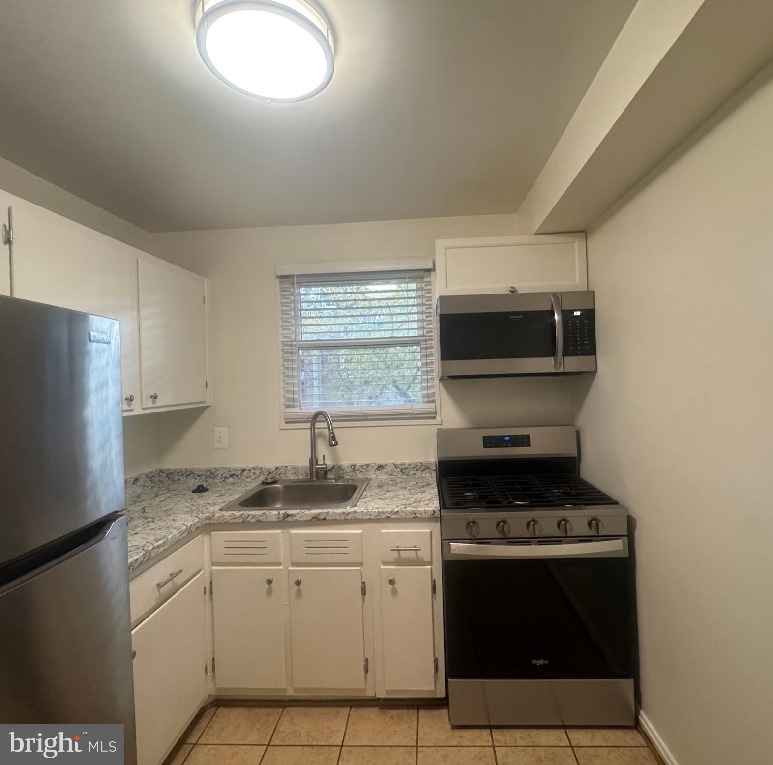 500 South Courthouse Road, Unit 9 Arlington, VA 22204 - Photo 8 of 18 a kitchen with granite countertop stainless steel appliances a stove a sink and a microwave