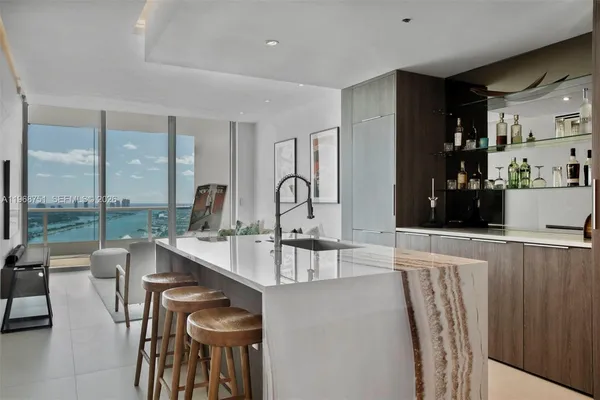 a room with stainless steel appliances kitchen island granite countertop furniture and a view of living room