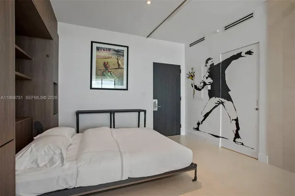 a bedroom with a bed and a painting on the wall