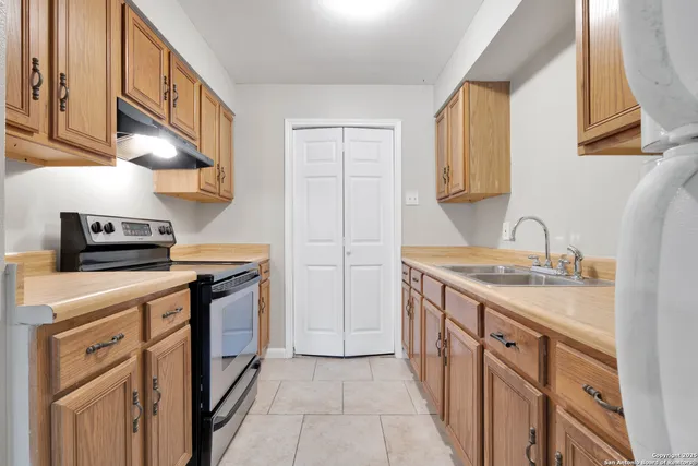 a kitchen with stainless steel appliances granite countertop a sink and a stove