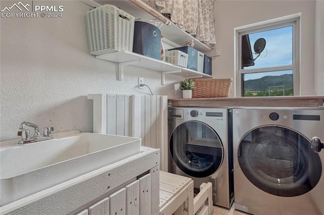 2690 Spaatz Road Monument, CO 80132 - Photo 14 of 50 Clothes washing area with sink, washing machine and dryer, and a mountain view