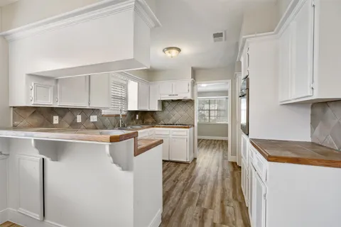 a kitchen with stainless steel appliances granite countertop white cabinets sink and window