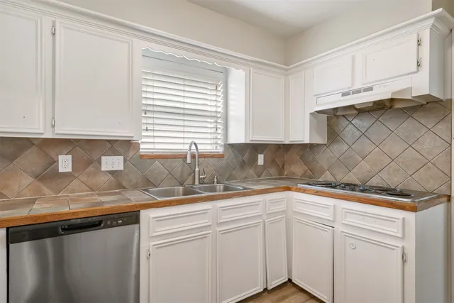 a kitchen with granite countertop white cabinets and white appliances