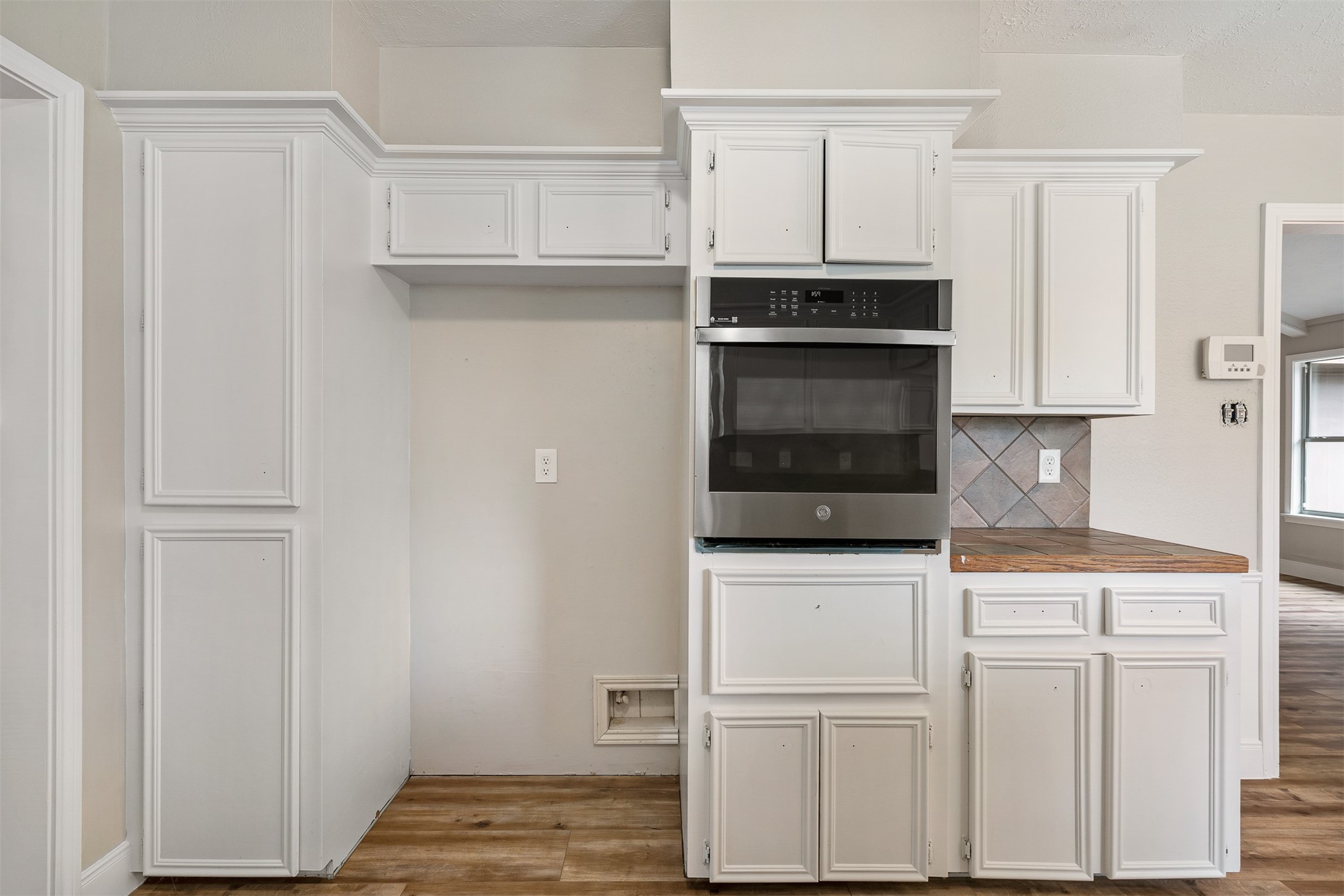 25519 Many Oak Drive Spring, TX 77380 - Photo 15 of 33 a kitchen with white cabinets and stainless steel appliances