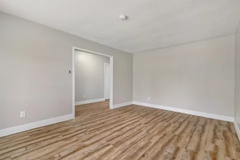 a view of an empty room with wooden floor