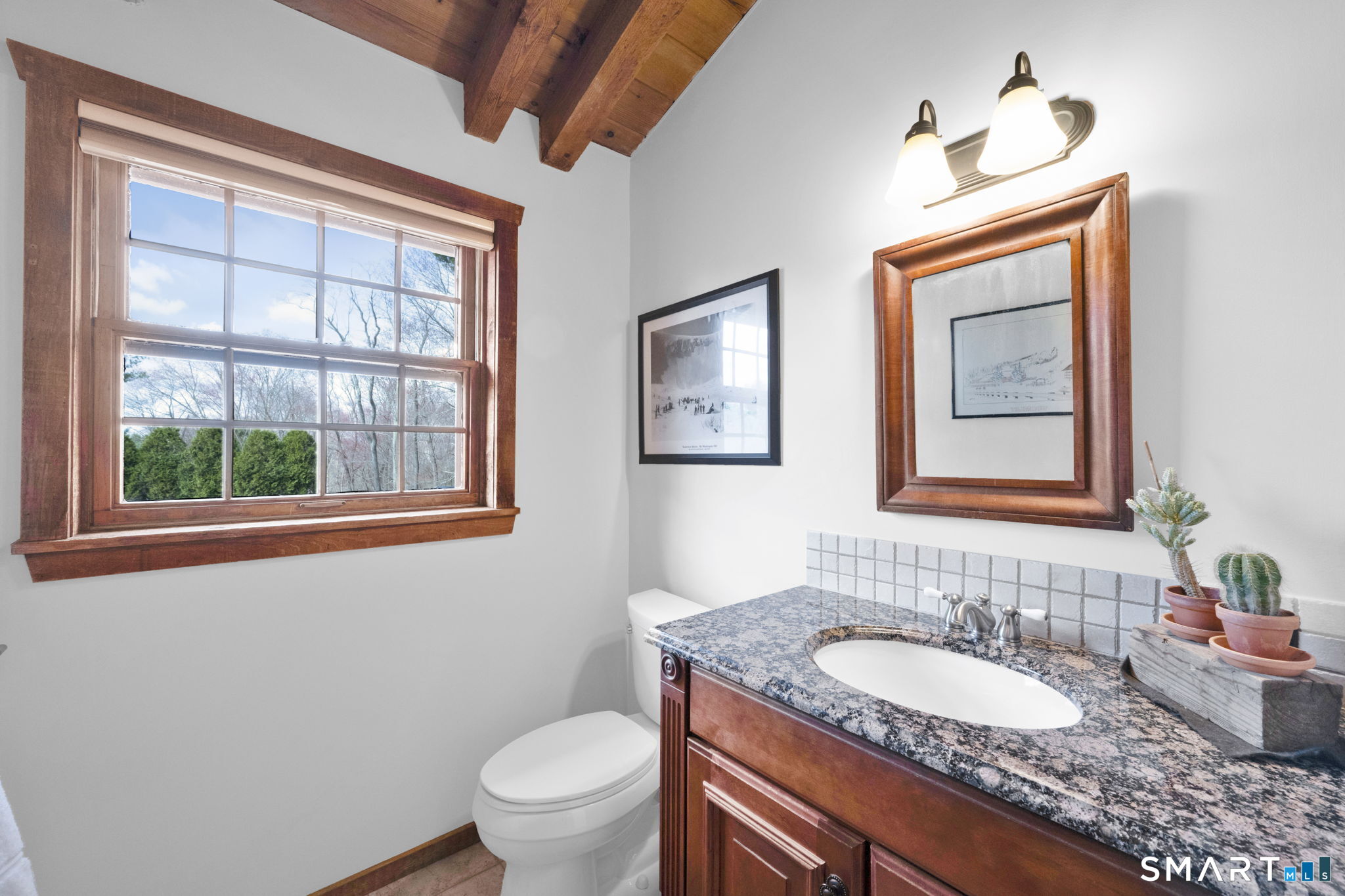 260 West Street Hebron, CT 06248 - Photo 12 of 40 a bathroom with a granite countertop toilet a sink and a window