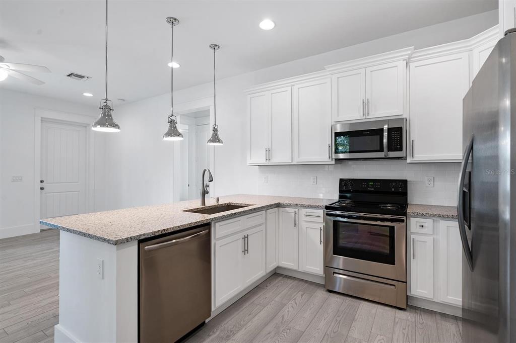 667 Southwest Cleveland Avenue, Unit 2 Stuart, FL 34994 - Photo 3 of 10 a kitchen with a sink stove and microwave