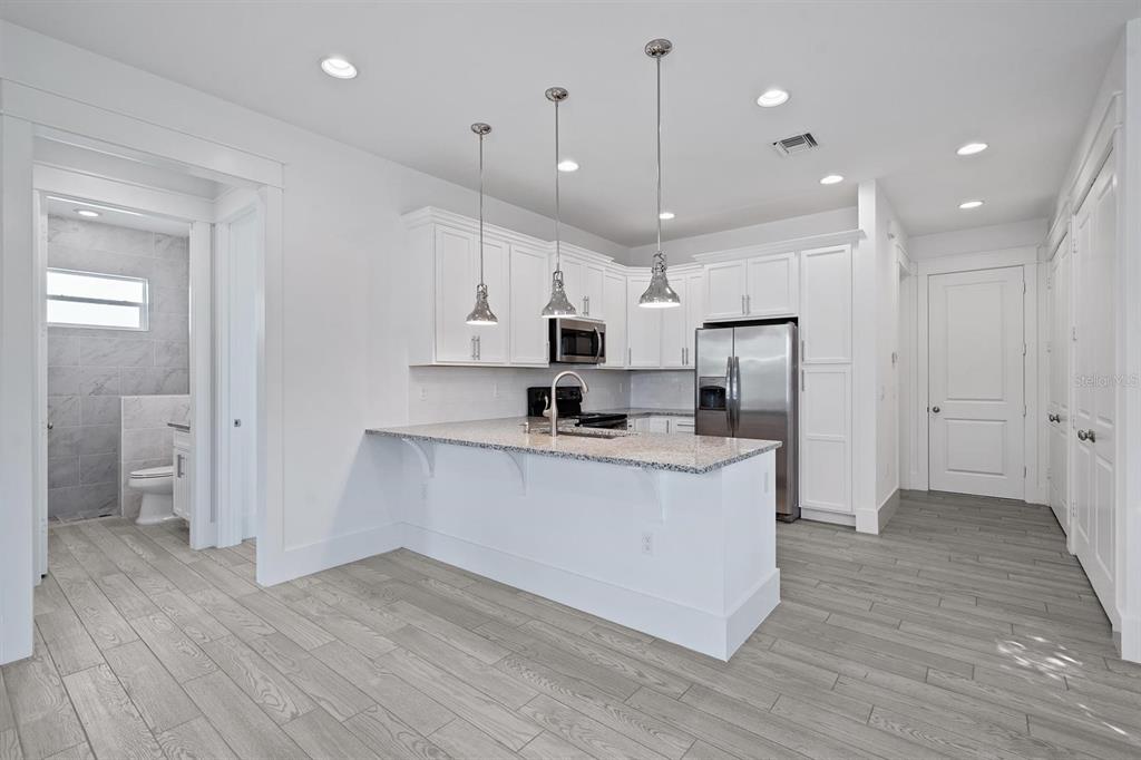 667 Southwest Cleveland Avenue, Unit 2 Stuart, FL 34994 - Photo 4 of 10 a large kitchen with stainless steel appliances granite countertop a large counter top a sink and a refrigerator