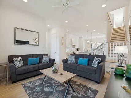 a living room with furniture and a wooden floor