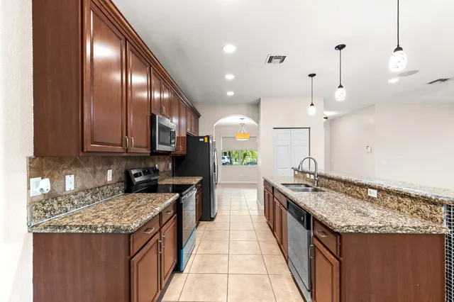 a kitchen with a stove and a wooden floor