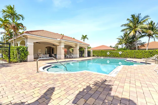 a view of house with swimming pool and yard