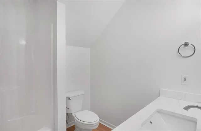 a white toilet sitting next to a bath tub