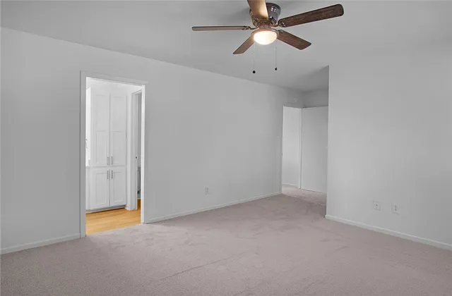 an empty room with a ceiling fan and fan