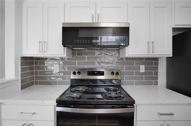 a stove top oven sitting inside of a kitchen