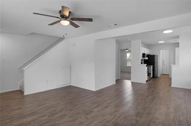a view of a big room with wooden floor and a ceiling fan