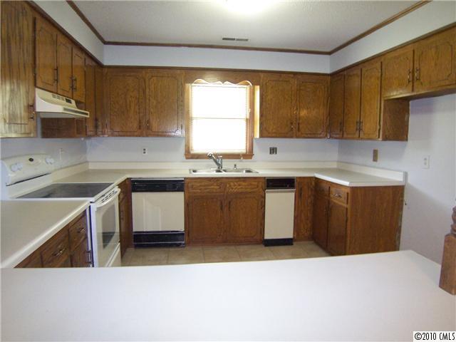 409 Robinson Creek Road Bostic, NC 28018 - Photo 3 of 9 a kitchen with a sink a stove a refrigerator a center island and cabinets