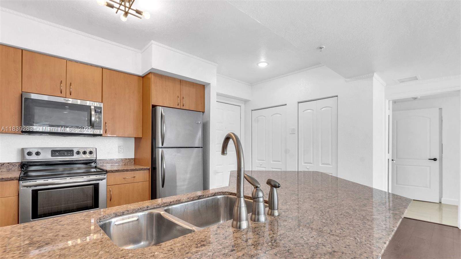1830 Radius Drive, Unit 405 Hollywood, FL 33020 - Photo 14 of 28 a kitchen with stainless steel appliances granite countertop a refrigerator a stove a sink and a microwave