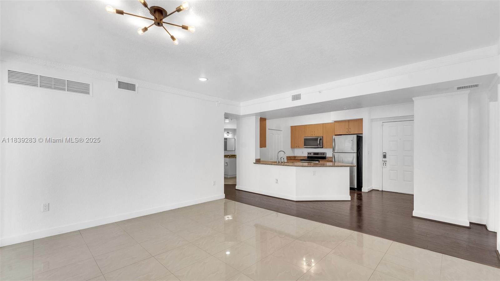 1830 Radius Drive, Unit 405 Hollywood, FL 33020 - Photo 16 of 28 a living room with a couch and chandelier