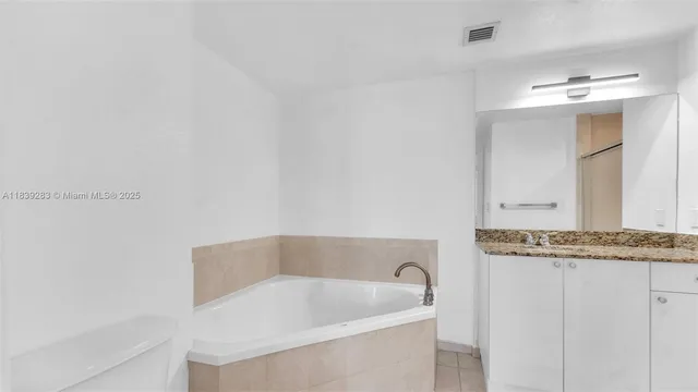 a bathroom with a granite countertop bathtub and sink