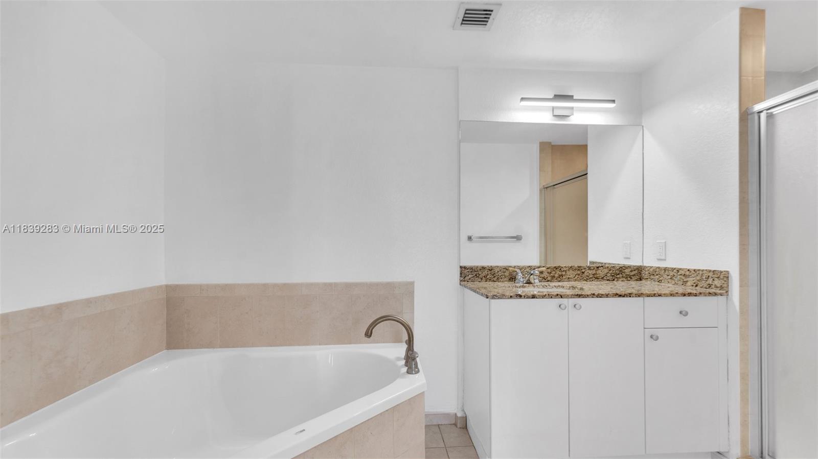 1830 Radius Drive, Unit 405 Hollywood, FL 33020 - Photo 20 of 28 a bathroom with a granite countertop bathtub and sink