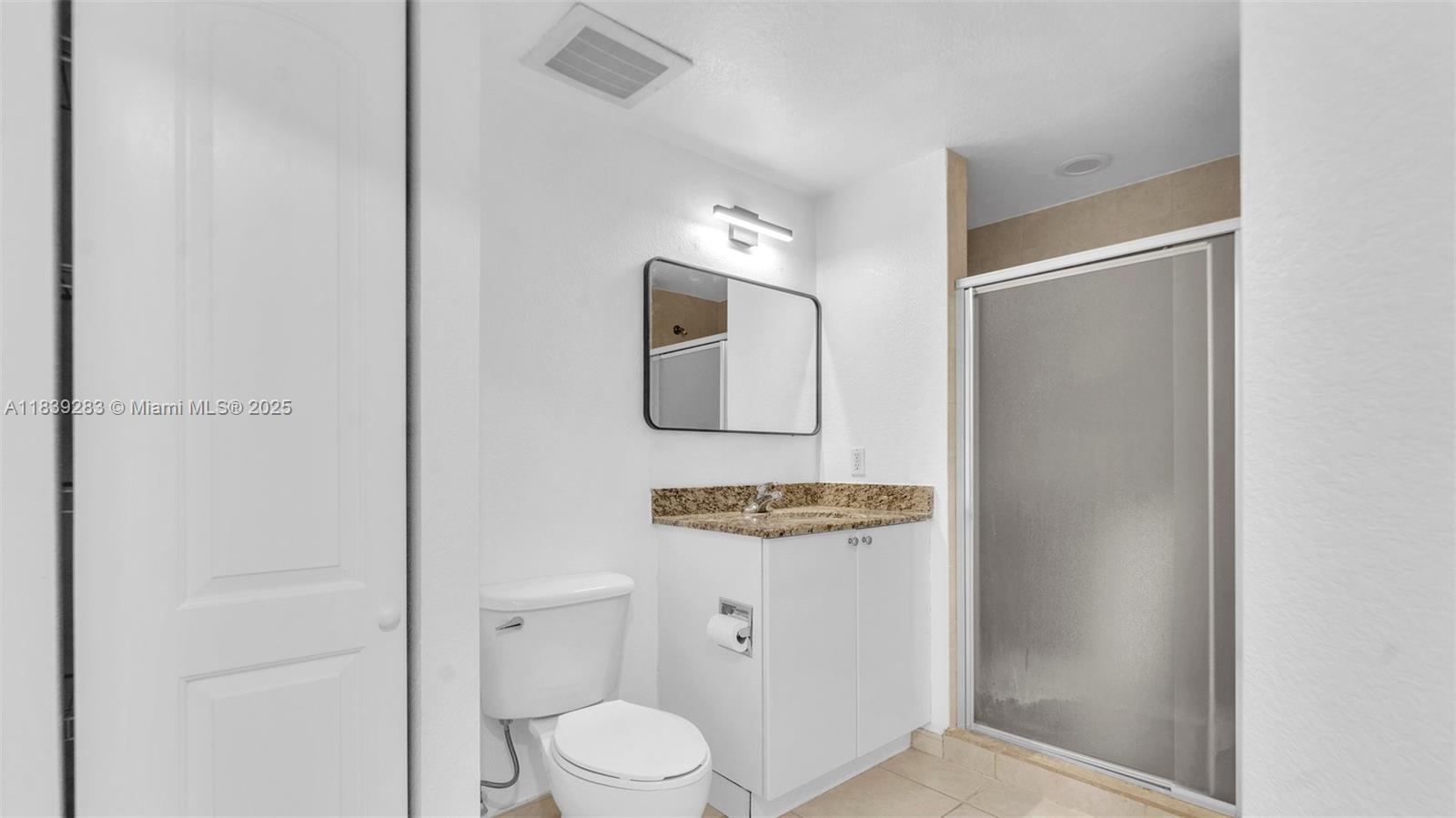 1830 Radius Drive, Unit 405 Hollywood, FL 33020 - Photo 24 of 28 a bathroom with a toilet sink and mirror