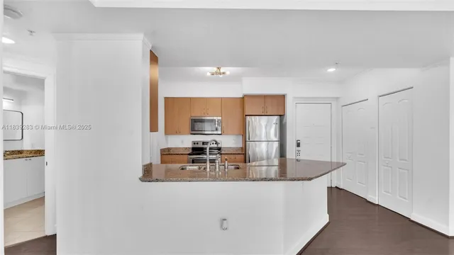 a kitchen with kitchen island a sink appliances and a counter top space