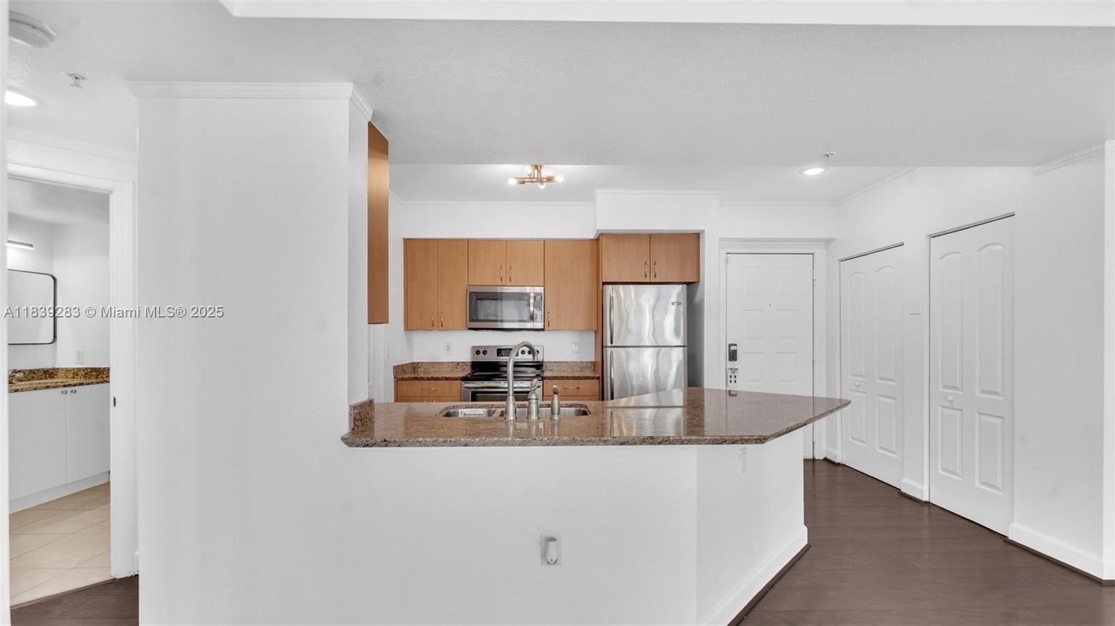 1830 Radius Drive, Unit 405 Hollywood, FL 33020 - Photo 9 of 28 a kitchen with kitchen island a sink appliances and a counter top space