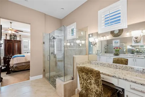 a bathroom with a granite countertop sink a mirror and shower