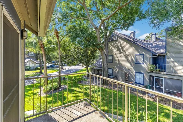 a view of a balcony with floor to ceiling windows and wooden fence