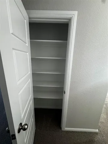 a view of walk in closet with empty racks